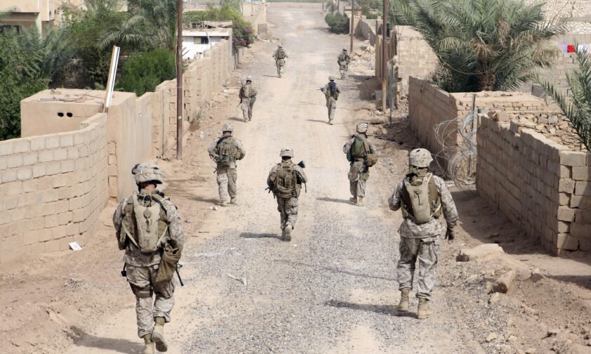 American Soldiers on Patrol down dusty road